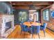 Dining room with fireplace, exposed beam ceiling, wood floors, and comfortable blue chairs at 21 1/2 Pitt St, Charleston, SC 29401