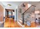 Bright entryway with hardwood floors, stairs with black railing, and a view into the dining room at 21 1/2 Pitt St, Charleston, SC 29401