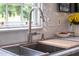 Modern kitchen sink with white tile backsplash, stainless steel faucet, and a garden view at 21 1/2 Pitt St, Charleston, SC 29401