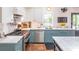 Well-equipped kitchen featuring blue cabinetry, stainless steel appliances, and a marble countertop at 21 1/2 Pitt St, Charleston, SC 29401