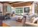 Bright and airy living room showcasing a fireplace, exposed beams, a large sectional, and hardwood floors at 21 1/2 Pitt St, Charleston, SC 29401