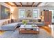 Comfortable living room featuring a gray sectional, wood floors, a modern coffee table, and two windows at 21 1/2 Pitt St, Charleston, SC 29401