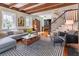 Cozy living room with a gray sectional, a stylish coffee table, and a staircase at 21 1/2 Pitt St, Charleston, SC 29401