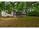 Home exterior with screened-in porch, lush lawn and mature trees at 2169 Westrivers Rd, Charleston, SC 29412
