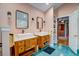 Stylish bathroom with dual sinks, wooden cabinetry, and a doorway leading to another room at 2169 Westrivers Rd, Charleston, SC 29412