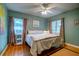 Cozy bedroom with hardwood floors, ceiling fan, and windows dressed with decorative curtains at 2169 Westrivers Rd, Charleston, SC 29412