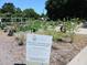 This welcome sign to the Charleston Parks Conservancy Community Garden stands in front of many different planted garden beds at 2169 Westrivers Rd, Charleston, SC 29412