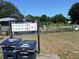 The compost containers stand in front of a City of Charleston informational sign, with a community garden in the background at 2169 Westrivers Rd, Charleston, SC 29412