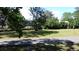 Expansive front lawn with mature trees, landscaping, and quiet walking path at 2169 Westrivers Rd, Charleston, SC 29412