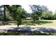 Expansive front lawn with mature trees, landscaping, and quiet walking path at 2169 Westrivers Rd, Charleston, SC 29412