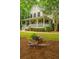 Landscaped front yard featuring lush greenery and a decorative wheelbarrow planter at 225 River Oak Dr, Mount Pleasant, SC 29464