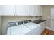 Bright laundry room with white cabinets, black countertops, and modern washer and dryer units at 225 River Oak Dr, Mount Pleasant, SC 29464