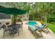 Backyard with a private pool, lounge chairs, and an umbrella-covered dining area, perfect for entertaining at 225 River Oak Dr, Mount Pleasant, SC 29464
