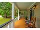 Inviting front porch with a rocking chair, decorative pillow, and views of the lush surroundings at 225 River Oak Dr, Mount Pleasant, SC 29464