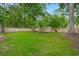 Spacious fenced backyard with lush green grass and mature trees, perfect for outdoor activities at 2436 Stingray Blvd, North Charleston, SC 29406