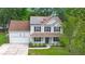 Two-story home with solar panels, a front porch, green lawn, and a two-car garage and ample parking at 2436 Stingray Blvd, North Charleston, SC 29406