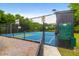 Community basketball court surrounded by a tall fence and lush trees, with a clearly visible security notice at 2520 Woodstream Rd, Mount Pleasant, SC 29466