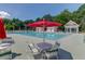 Community pool with a view of a white pool house, featuring red umbrellas and plenty of lounge chairs at 2520 Woodstream Rd, Mount Pleasant, SC 29466