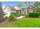 Inviting home featuring a brick facade, neutral siding, green shutters and lush landscaping at 2520 Woodstream Rd, Mount Pleasant, SC 29466