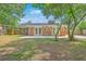 Backyard featuring a brick house, wood fence, green trees, and a concrete patio at 2534 Flamingo Dr, Charleston, SC 29414