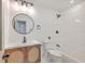 Bright bathroom featuring shower-tub, round mirror, and wood vanity with modern fixtures at 2534 Flamingo Dr, Charleston, SC 29414