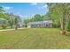 Beautifully landscaped front yard showcasing a single-story brick home with a light blue front door and shutters at 2534 Flamingo Dr, Charleston, SC 29414
