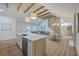 Open-concept living space featuring wood floors, wood beam vaulted ceilings, a dining area, and a comfortable seating area at 2534 Flamingo Dr, Charleston, SC 29414