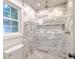 Elegant walk-in shower with grey and white marble-style tiling and a window at 2534 Flamingo Dr, Charleston, SC 29414