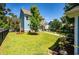 Manicured backyard with a mature tree, a screened-in porch, a concrete walkway, plants, and a fenced perimeter at 2627 Rutherford Way, Charleston, SC 29414