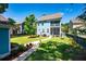 Fenced-in yard with green grass, a concrete walkway, mature trees, plants, and a screened-in back porch at 2627 Rutherford Way, Charleston, SC 29414