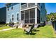 Backyard with a patio, screened-in porch above, and a well maintained lawn surrounded by a fence and trees at 2627 Rutherford Way, Charleston, SC 29414