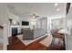 Well-lit living room with a cozy fireplace, white shutters, and an open view of the kitchen at 2627 Rutherford Way, Charleston, SC 29414