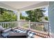 Covered porch with outdoor seating, and view of the lush backyard and the neighborhood at 2627 Rutherford Way, Charleston, SC 29414