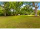 Large and attractive grassy backyard, shaded by mature trees and featuring practical outbuildings at 285 Roosevelt Dr, Saint Stephen, SC 29479