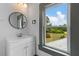 Bathroom featuring vanity with a round mirror and a view of the outside at 285 Roosevelt Dr, Saint Stephen, SC 29479