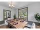 Bright dining room with wooden table, chandelier, and window view to the backyard at 285 Roosevelt Dr, Saint Stephen, SC 29479