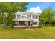Charming two-story home with a covered porch and a lush green lawn and mature trees at 285 Roosevelt Dr, Saint Stephen, SC 29479