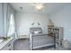 bedroom with wood accent wall, twin bed, window with sheer curtains and decorative shelving at 2962 Clearwater Dr, Mount Pleasant, SC 29466