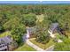 Aerial view showcasing a red brick home nestled among lush trees, with a golf course and neighboring houses visible nearby at 322 Clubview Rd, Summerville, SC 29485