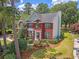 A stunning aerial view of a red brick home, manicured lawn, mature trees, and picturesque landscaping at 322 Clubview Rd, Summerville, SC 29485