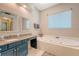 Bright bathroom featuring granite countertop, vanity, soaking tub, and window at 322 Clubview Rd, Summerville, SC 29485