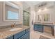 Bathroom with blue vanity, granite countertop, dual mirrors, and walk-in shower at 322 Clubview Rd, Summerville, SC 29485