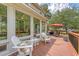 The deck offers comfortable seating, an umbrella, and views of the landscaped backyard and surrounding trees at 322 Clubview Rd, Summerville, SC 29485