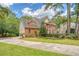 Brick home with a lush green lawn and landscaping, and long driveway leading to the attached garage at 322 Clubview Rd, Summerville, SC 29485