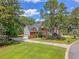 Beautiful two-story red brick home with a well-manicured lawn, mature trees, and a driveway leading to an attached garage at 322 Clubview Rd, Summerville, SC 29485