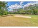 Scenic golf course view, featuring a pristine sand trap and lush green surroundings on a partly cloudy day at 322 Clubview Rd, Summerville, SC 29485