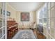 Sunlit study with hardwood floors, french doors, piano, guitar, and comfortable seating at 322 Clubview Rd, Summerville, SC 29485
