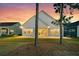 Backyard home view with sunset lighting featuring the patio, lawn, and neighboring homes at 327 Tupelo Lake Dr, Summerville, SC 29486
