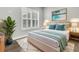 Stylishly staged bedroom with decorative pillows and large windows dressed with white shutters at 327 Tupelo Lake Dr, Summerville, SC 29486