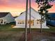Exterior home shot at sunset highlighting the patio, lawn, and neighboring homes at 327 Tupelo Lake Dr, Summerville, SC 29486